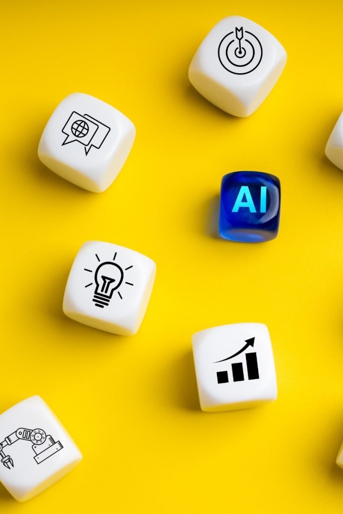 AI letters, chart and search marks on dice over yellow